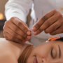 Person meditating with acupuncture needles